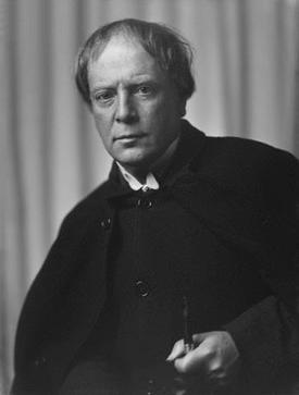 Portrait of author Arthur Machen holding a pipe, wearing a dark suit and looking intensely at the camera.